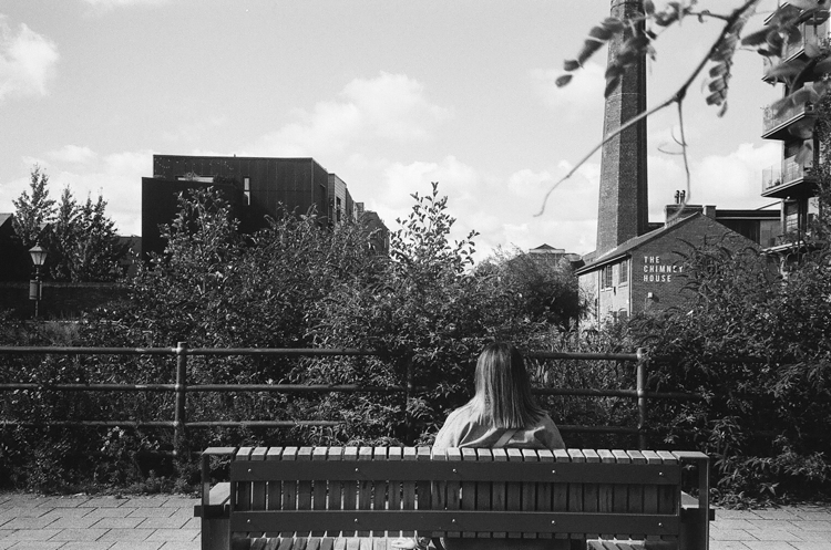 A women sat, unable to view anything due to the overgrown plantlife.